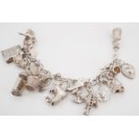 A silver charm bracelet, including ship-in-a-bottle, Aladdin lamp, Penny Farthing bicycle and