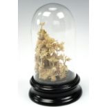 A Chinese carved cork pagoda and woodland on turned ebonised base under glass dome, 11 cm high