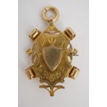 A late Victorian 9 ct gold fancy shield shaped watch chain fob medallion, 4 cm excluding