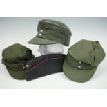 A reproduction Luftwaffe cap, a reproduction German army officer's peaked field service cap and