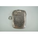 A George V silver Vesta case, contoured cushion shaped and foliate scroll engraved