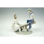 A Lladro porcelain figure group modelled as a young woman and a boy in sailors' uniform on a see-