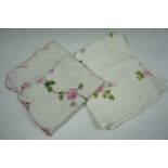 Two vintage hand-embroidered cotton tablecloths decorated in patterns of pick roses