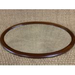 A George V mahogany framed oval bevel-edged wall mirror, 75 cm x 49 cm