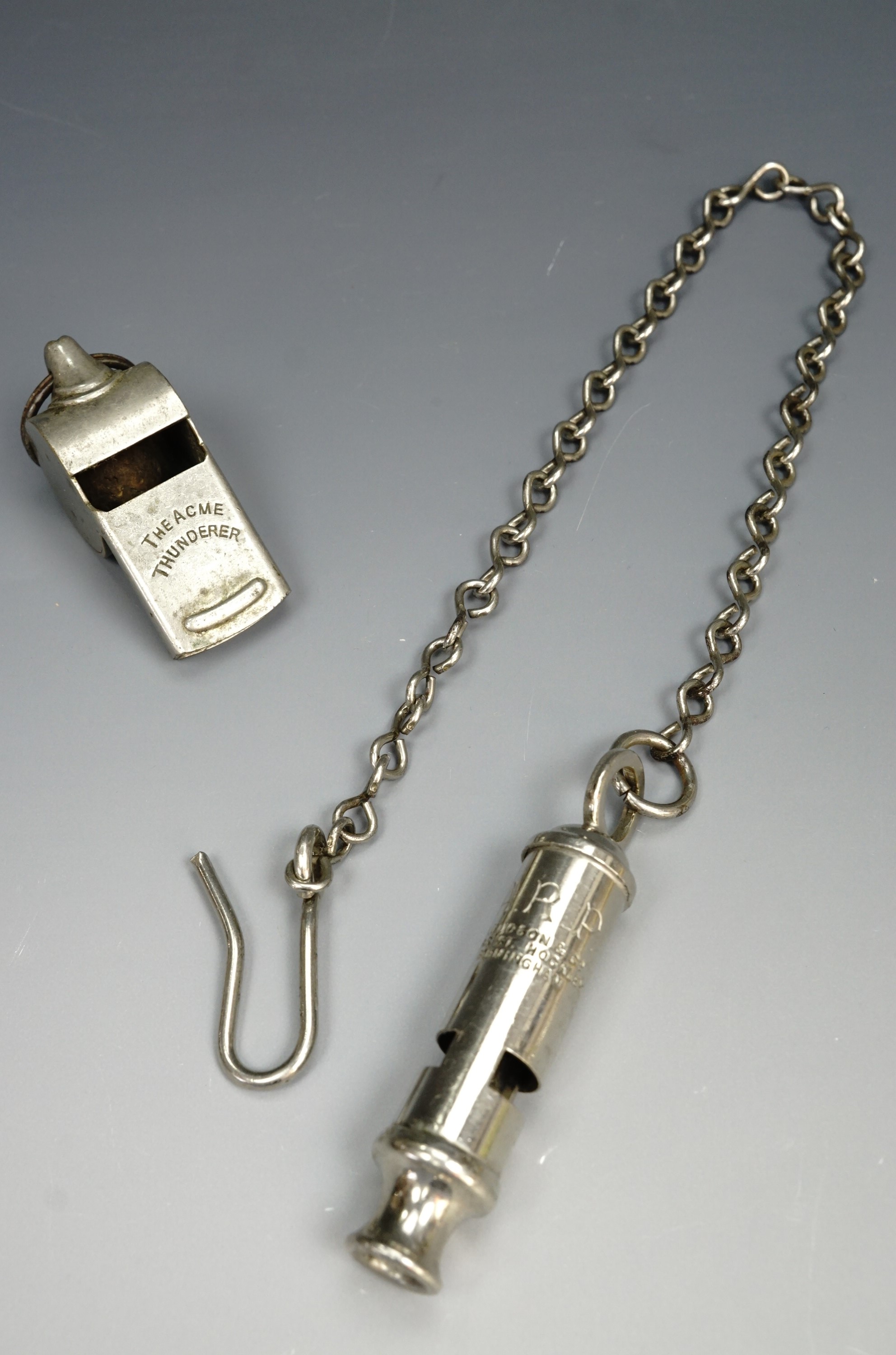 An ARP whistle and chain together with an Acme Thunderer snail whistle