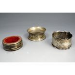 Two Victorian silver napkin rings with engraved decoration together with a silver wine bottle