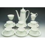 A Coalport six piece white china coffee set, later decorated with enameled trailing flowers.