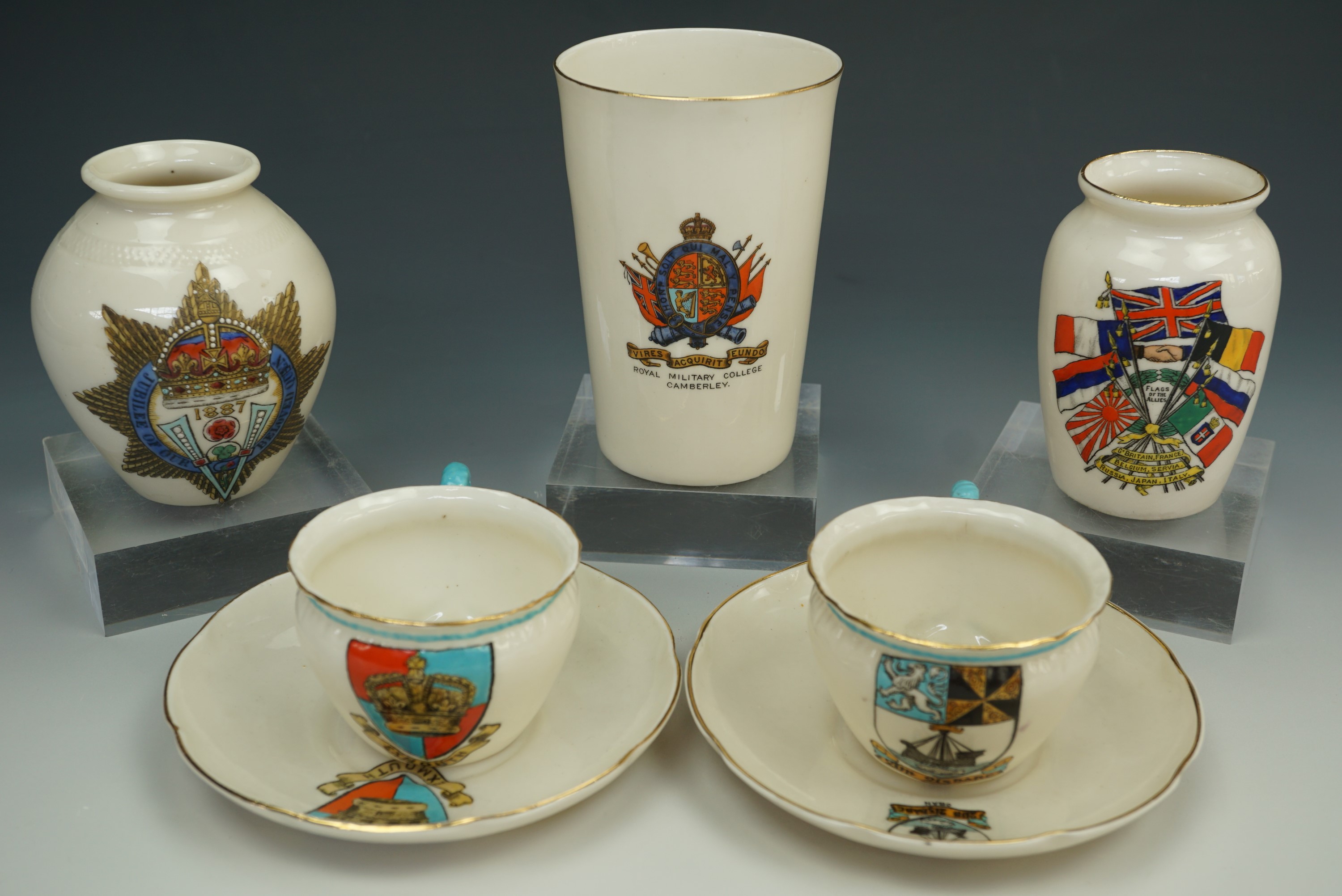 Two W.H. Goss cups and saucers together with three similar crested pots
