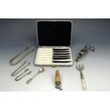A cased set of stainless steel butter knifes together with sugar tongs etc