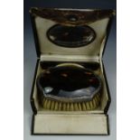 A cased faux turtleshell brush, comb and mirror travel dressing set, (a/f)