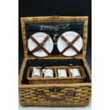 A wicker picnic hamper and contents