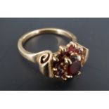 A garnet and 9 ct gold cluster ring, the flowerhead arrangement of faceted stones set between the