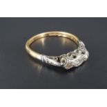 A vintage three stone diamond engagement ring, the stones platinum illusion set on and 18 ct gold
