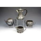 A three piece Craftsman pewter tea set together with one other teapot