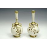 A pair of Royal Worcester blush ivory bottle vases, with slender neck and two handles to base,