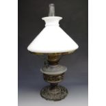 A 19th century German cast metal oil lamp, baroque influenced relief decoration, the glass reservoir