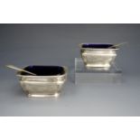 A Belle Epoque pair of silver salt cellars with spoons, having cobalt blue glass liners, Horace