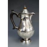 A Victorian silver baluster hot water jug, decorated with gadrooning and engraved floral swags,