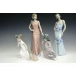 Four NAO figurines including two girls with puppies, tallest 30 cm