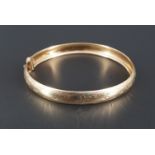 A floral-engraved 9 ct gold bangle, 60 mm x 52 mm, 6.1 g