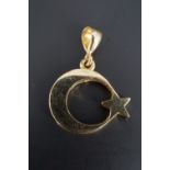 A 14 K yellow metal star and crescent pendant, 15 mm excluding suspender, 2.5 g