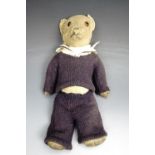 A pre-war early 20th century golden plush wood wool filled articulated Teddy bear, having glass eyes