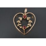 An early 20th Century heart shaped openwork pendant, the heart enclosing a wreath set with seed