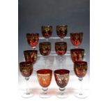 Six ruby and gilt wine glasses together with six wine goblets