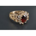 A 1970s garnet and white stone dress ring, the oval faceted garnet of approx 7 mm x 5 mm set on a
