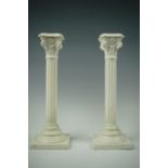 A pair of 1880s German creamware candlesticks formed as Corinthian columns, impressed beehive mark
