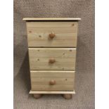 A contemporary pine effect bedside chest