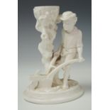 A 19th century continental rococo influenced blanc de chine figural candle holder, formed as a boy