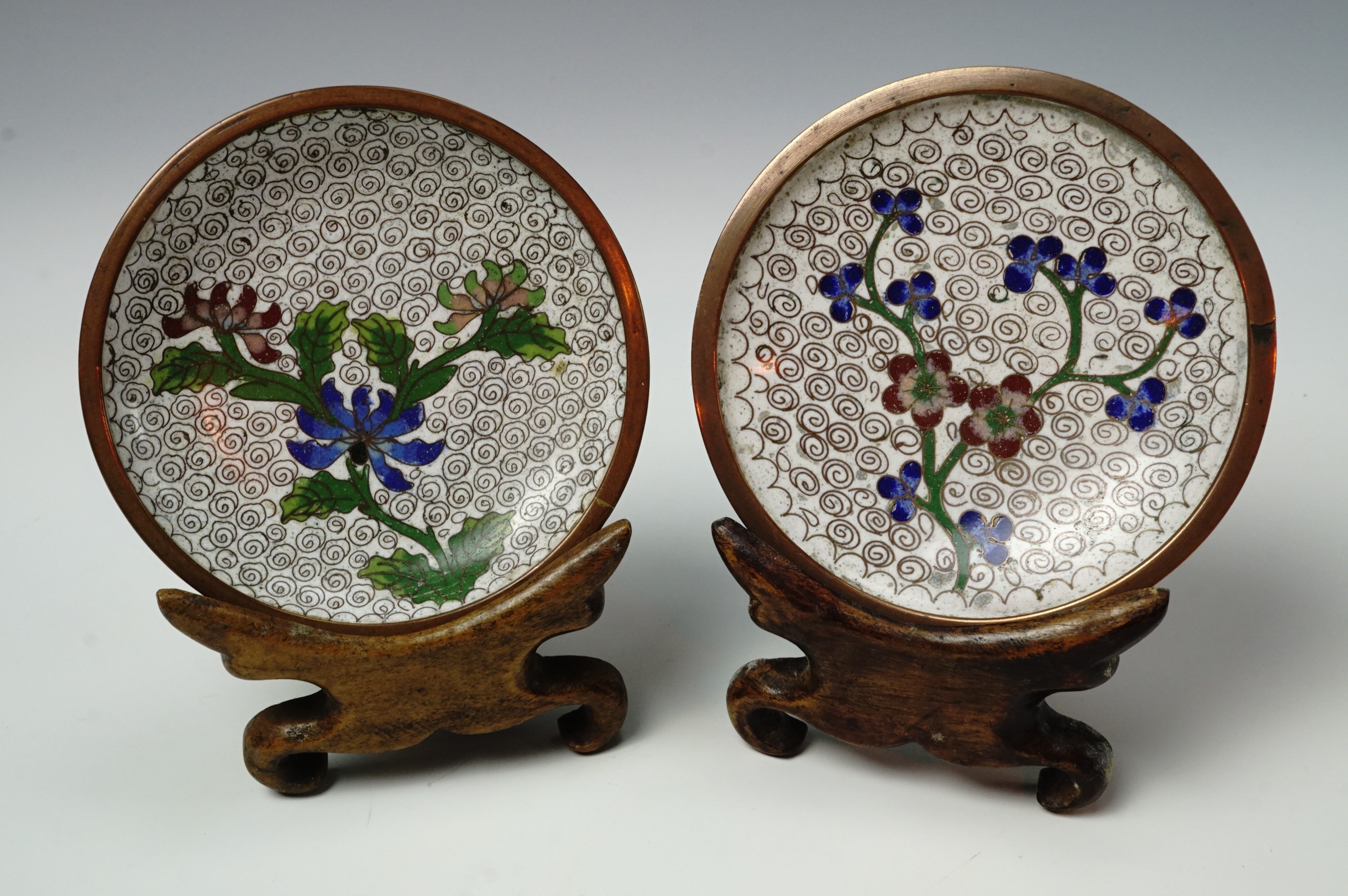 A pair of 20th century Chinese cloisonne dishes and wooden stands, 9.5 cm diameter