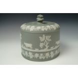 An early 20th century Wedgwood influenced green Jasperware cheese dome, sprig decorated with