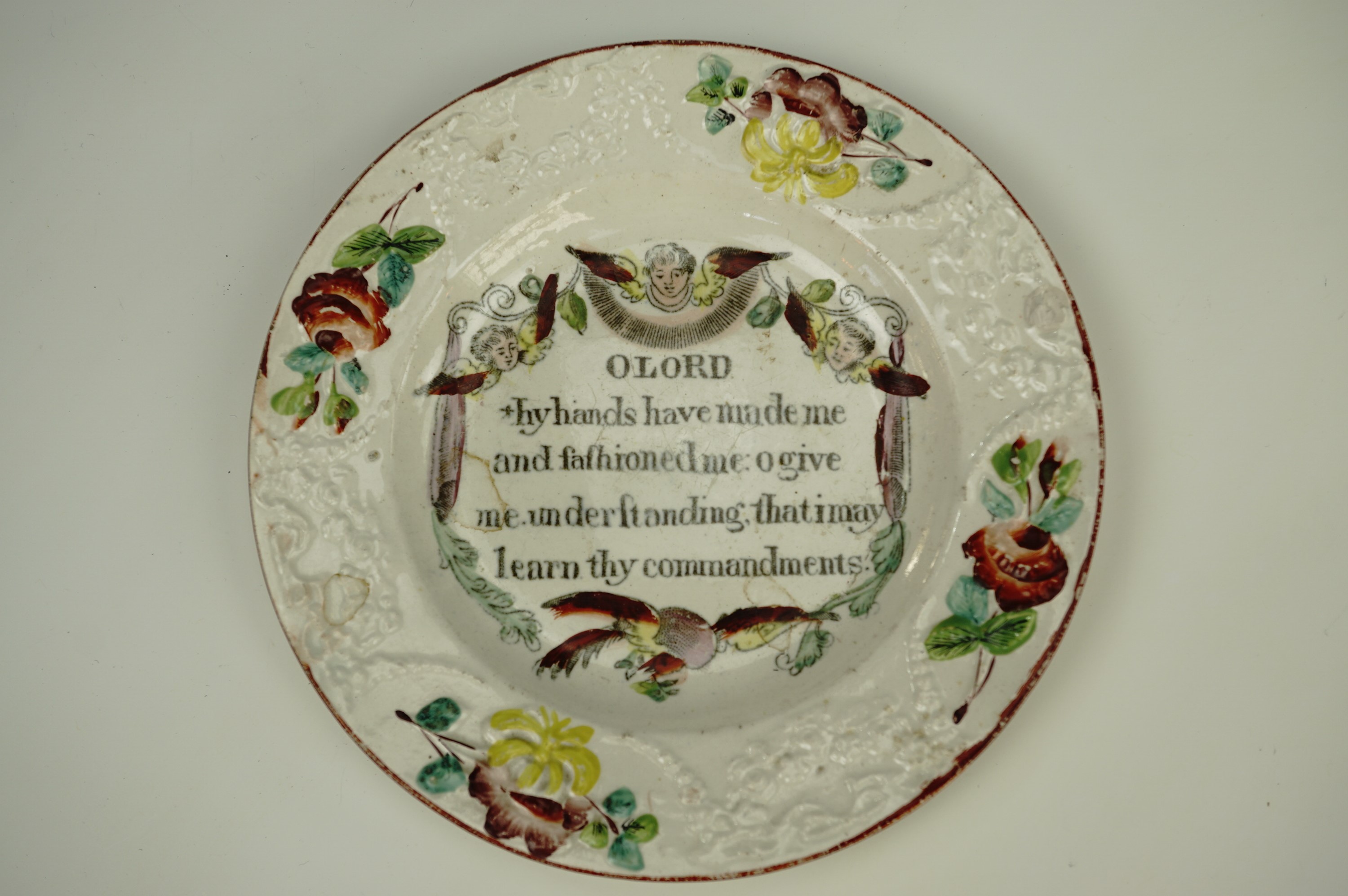 A Victorian sentimental plate with moulded decoration highlighted with enamels and a central