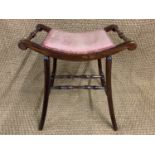A late 19th / early 20th Century Theban influenced upholstered mahogany dressing table stool