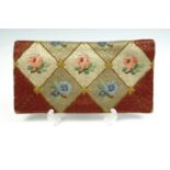 A vintage clutch bag, embroidered with reticulated square panels and floral motifs, having two inner
