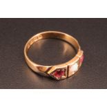 An Edwardian 18 ct ruby and opal ring, having three geometric panels with an opal cabochon set