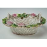 An Edwardian porcelain bonbon basket, formed of lattice openwork with bocage decorated rim and two