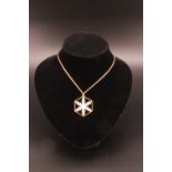 A contemporary parcel gilt white metal snowflake pendant, 3.5 cm