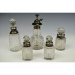 Four silver-collared cut glass toiletry bottles together with an electroplate mounted perfume