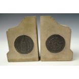 A pair of carved stone bookends bearing cast lead plaques, together with a 1942 certificate