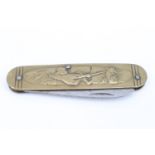 A late 19th / early 20th Century humorous novelty pocket folding knife, its brass grip scales relief