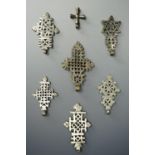 Seven white metal Ethiopian Coptic Christian crosses, cast with pierced design, largest 8 cm.