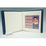 A folder of Elvis Presley commemorative stamp sets, approximately fifty