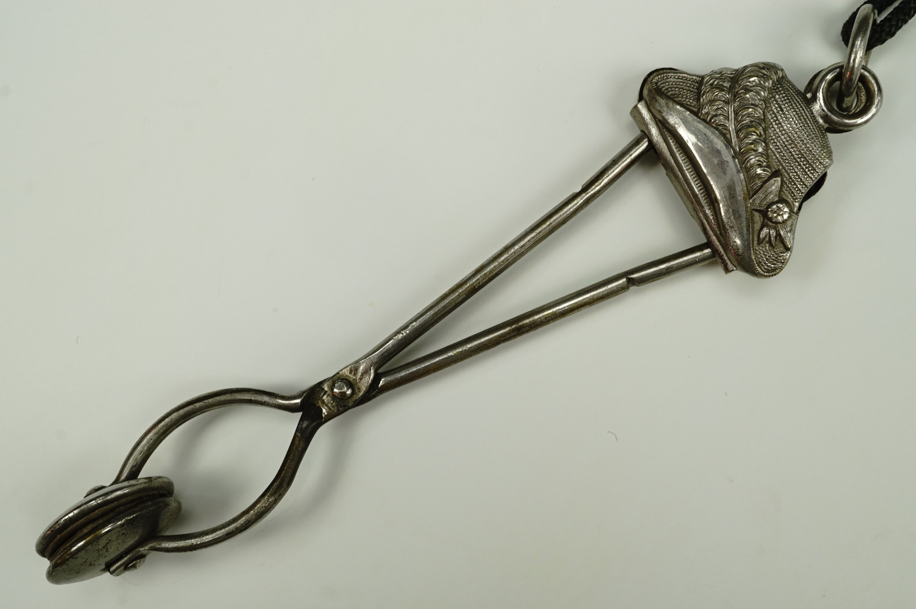 A Victorian lady's electroplate skirt lifter, its terminal modelled as a bonnet, 15 cm