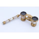 A pair of Belle Epoque French gilt brass and mother of pearl opera glasses having a fold out handle,