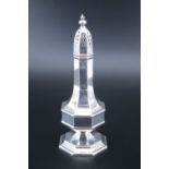 A silver sugar caster of baluster form, having octagonal faceted sides and lift out pierced lid,