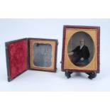 Two Victorian daguerreotypes, a seated gentleman in an oval mount within a gilt frame in a leather