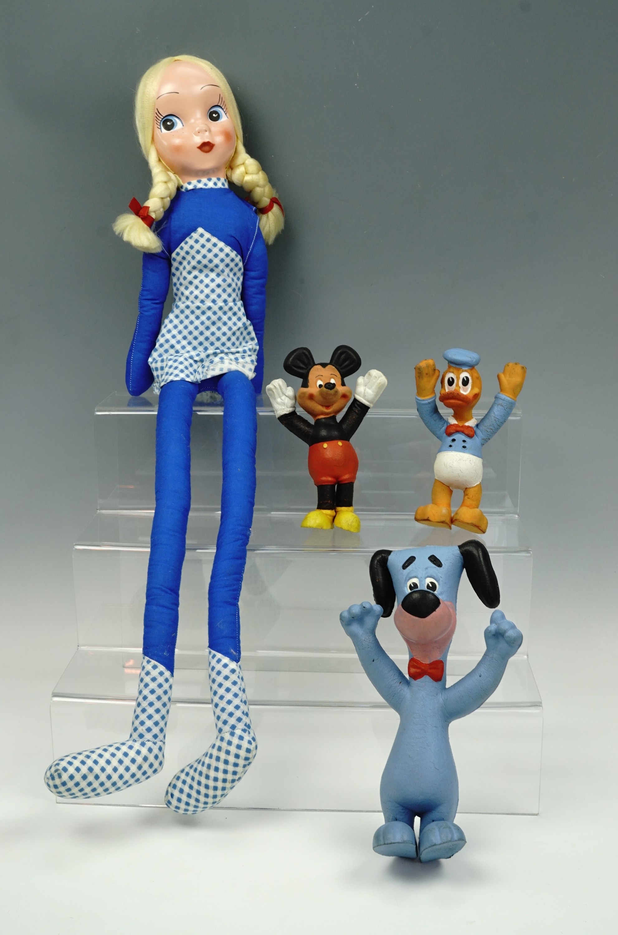Three bendy toys; Donald Duck, Mickey Mouse and Huckleberry Hound, together with a doll